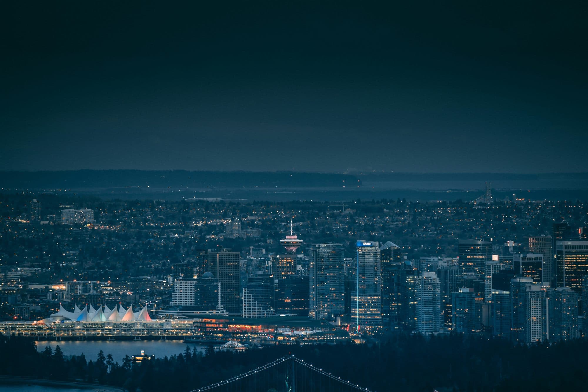 Downtown Vancouver skyline at dusk, with the North Shore mountains behind.